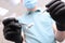 Dentist`s hands in black latex gloves with medical instruments . Face out of focus. POV. Copy of the space