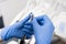 Dentist`s hands with blue gloves configure dental drill in dental office