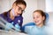 Dentist showing instrument for repairing teeth to girl in dental