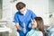 Dentist Showing Mirror To Teenage Girl In Clinic