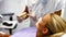 Dentist showing model teeth to female patient