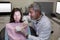 Dentist showing mouth model to female patient