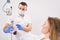 Dentist showing tooth model to woman in dental clinic