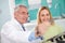 Dentist shows dental film to female patient