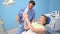 Dentist shows patient the results of treatment with a mirror, examining teeth with dental equipment in dental office