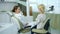 Dentist sits in patient chair and talks with girl