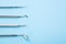Dentist tools. Professional steel dental instruments with a mirror on light blue background with free space. Dental health and