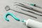 Dentist tools and toothpaste in the shape of a question mark. Mirror, hook, tweezers and syringe tools. Concept of how