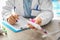 Dentist with toothbrush and paste sitting at table in office