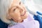 Dentist treating old lady teeth with dental pneumatic spray gun