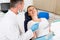 Dentist in uniform is taking examination of a young female