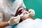 Dentist using whitening ultraviolet lamp on her teeth. Young girl patient at the dental clinic lies in uv glasses on the dentist`s