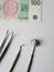 dentist utensils for oral review and czech banknote of 100 korun