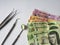 dentist utensils for oral review and mexican banknotes