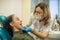 Dentist woman doing teeth checkup of teen girl in a dental chair