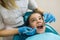 Dentist woman doing teeth checkup of teen girl in dental chair