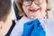 Dentist woman performing dental bleaching at senior patient