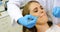 Dentists examining a female patient with tools