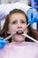 Dentists examining a young patient with tools