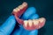 Denture. Partial removable denture of the lower jaw of a person with white beautiful teeth in the hand of a dentist. Aesthetic