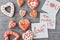 Deocrated heart shape cookies and paper sheets with inscriptions be mine, love and i love you on the gray background. Valentines