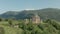 Departure on a drone from the ancient dilapidated Christian church standing high on the mountain. Aerial View. North