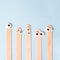 Depilation, medical and beauty concept - wooden waxing spatula sticks with funny eyes on blue background, advertizing creative