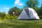 A deployed tent on a sunny day on a green lawn.