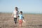Deportation concept of refugee orphan family boy and girl holding hands walking in hot desert near state border seeking for