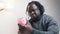 Depresed African american black man holding empty piggy bank. Financial crisis