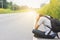 depress and hopeless , Travel hitchhiker man with backpack sitting on roadside, waiting for car