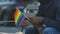 Depressed Afro-American boy holding rainbow flag, sexual orientation bullying