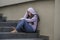 Depressed Asian Chinese student woman or bullied teenager girl sitting outdoors on street staircase victim of bullying feeling