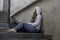 Depressed Asian Japanese student woman or bullied teenager girl sitting outdoors on street staircase victim of bullying feeling