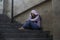 Depressed Asian Korean student woman or bullied teenager girl sitting outdoors on street staircase victim of bullying feeling