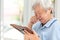 Depressed asian senior woman holding a picture frame and watching old photographs of family at home,devastated elderly people