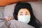 depressed Asian woman in bed with face mask scared and panic getting sick of coronavirus