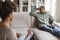 Depressed black man reclining on couch at counselor office