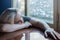 Depressed blonde woman laying on her hands on a kitchen table