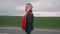 Depressed blonde woman is walking on the road. Lonely girl with a red scarf.