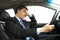 Depressed businessman holding head and driving car