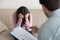 Depressed crying woman sitting with her head down, psychologist