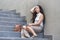 Depressed and desperate Asian Chinese businesswoman crying alone sitting on street staircase suffering stress and depression