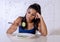 Depressed dieting woman holding folk looking at small green vegetable on empty plate