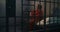 Depressed female prisoner sits on bed in prison cell