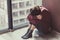 Depressed lonely young woman sitting alone on floor at home