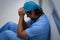 Depressed male surgeon sitting and leaning in the corridor at hospital