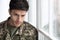 depressed military guy standing next to window, closeup
