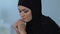 Depressed muslim woman in hijab thinking about problems, sitting alone at home
