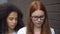 Depressed red-haired teenager eyeglasses suffering insulting classmate, conflict